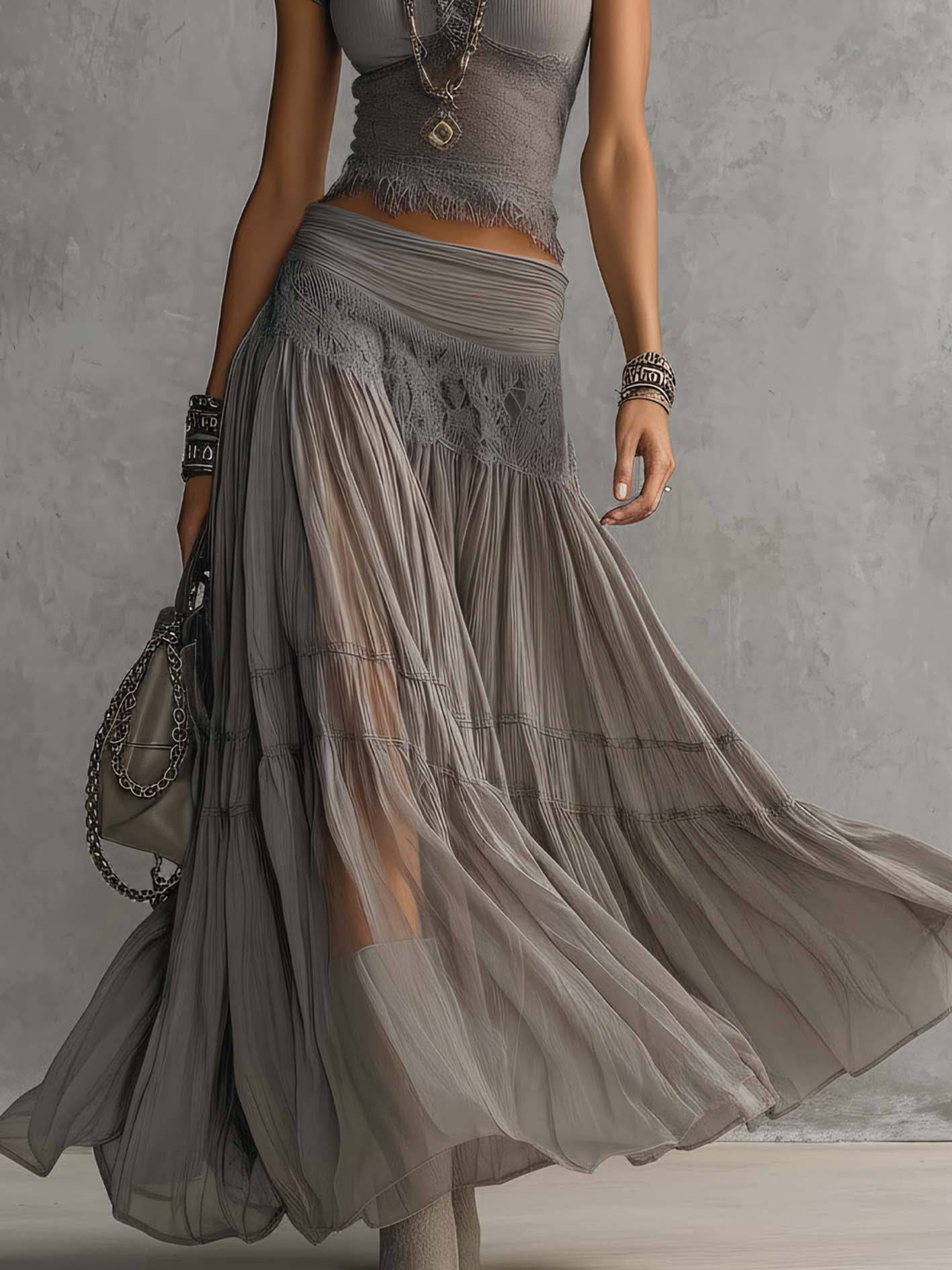 Ensemble coordonné gris avec top en dentelle transparente et jupe longue plissée, de la marque Danoir Paris.