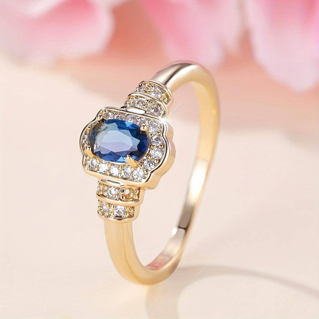 Bague Danoir Paris en or avec saphir hérité entouré de cristaux, style halo, bijou élégant pour femme.