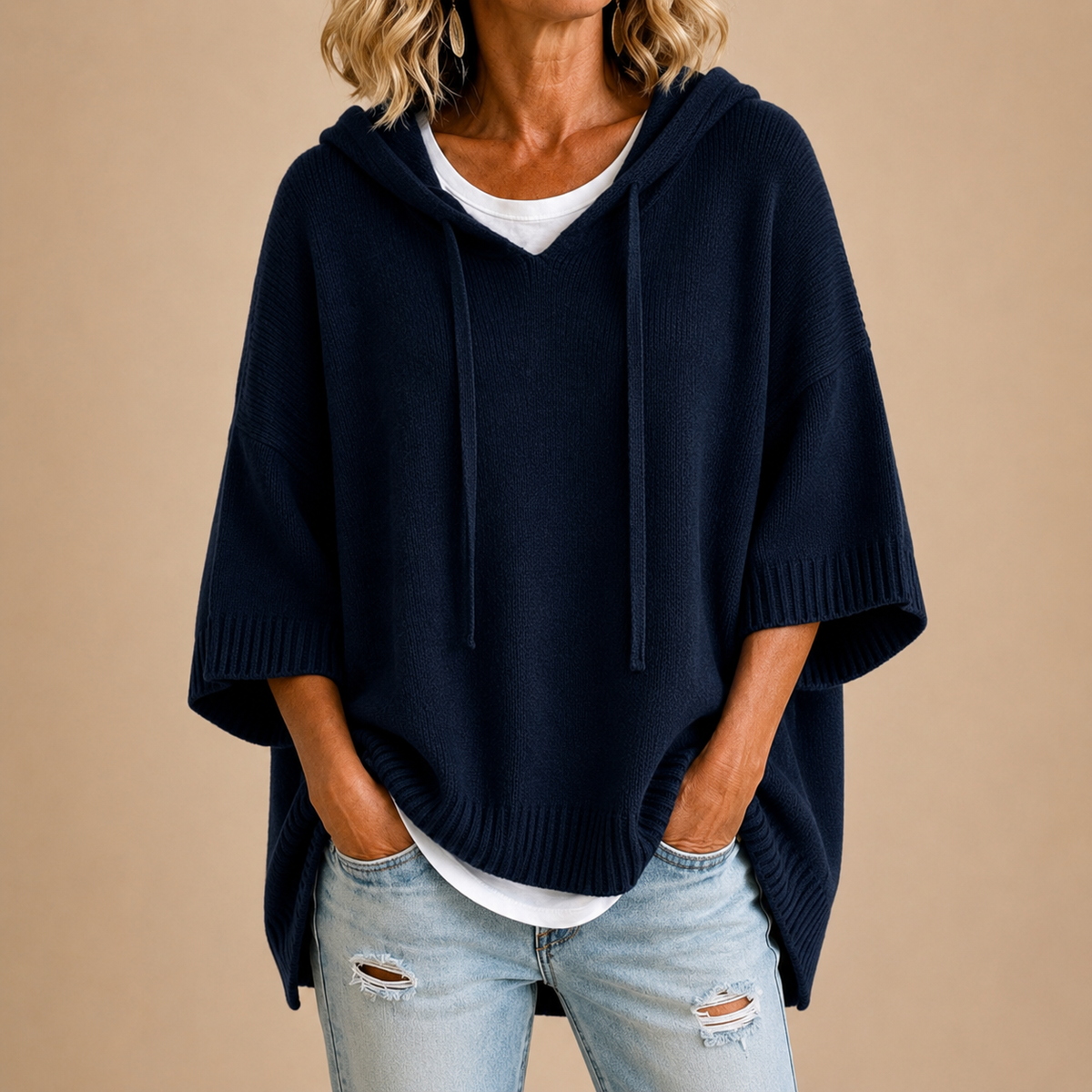 Poncho en maille avec capuche Mirella™ de Danoir Paris, porté, en tissu doux et élégant, idéal pour la saison automne-hiver.