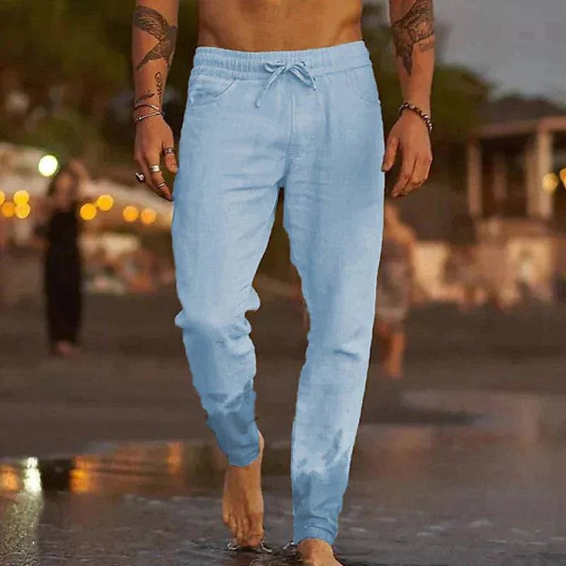 Pantalons de plage en lin Mateo de Danoir Paris, style décontracté, tissu léger blanc avec ceinture à nouer, idéal pour l'été.