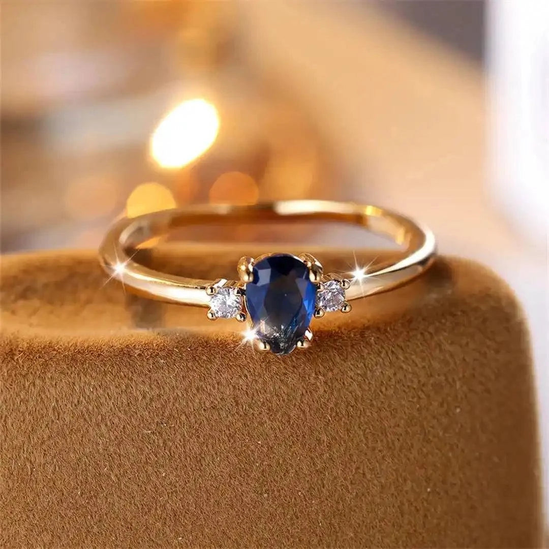 Bague minimaliste en or blanc avec saphir royal en forme de poire, design élégant par Danoir Paris.