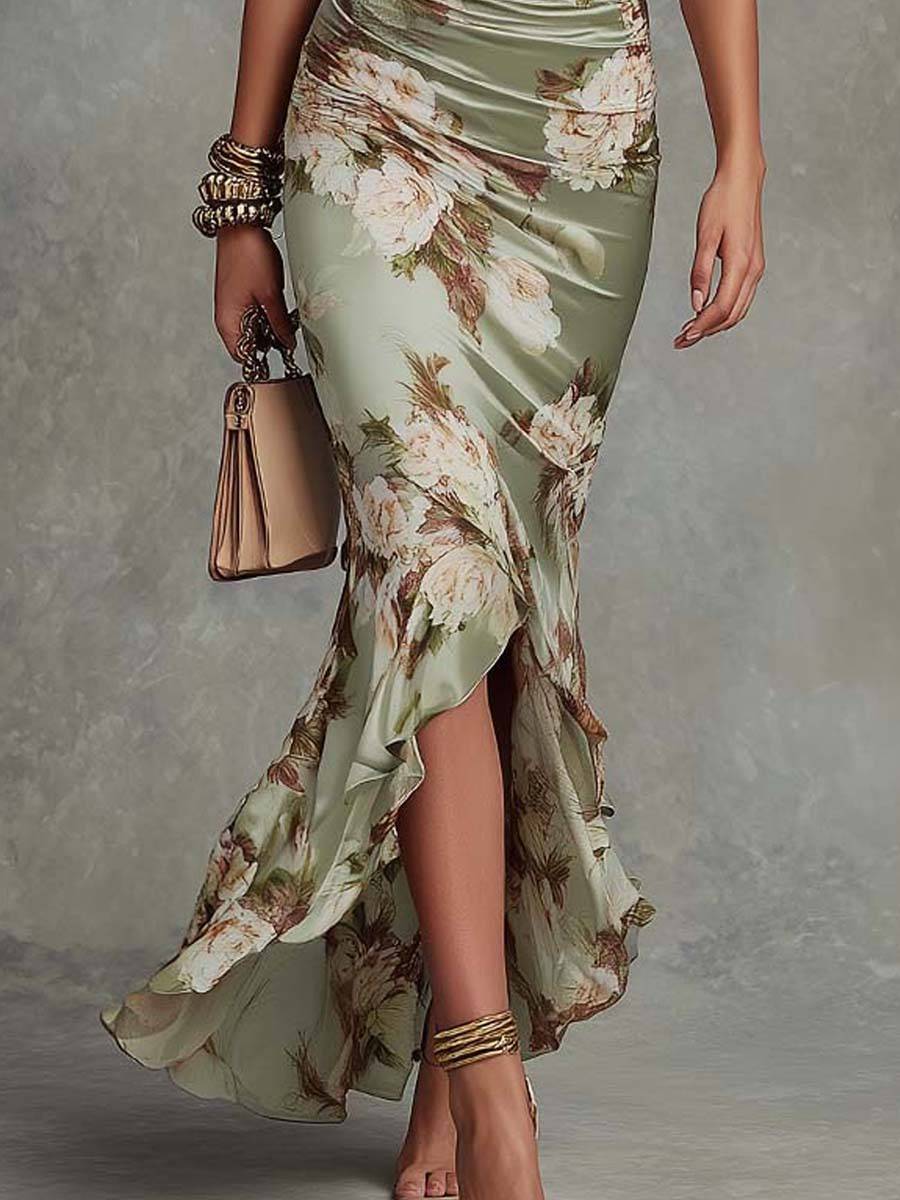 Robe longue satin verte à fleurs avec manches bell et décolleté en V, style asymétrique, de la marque Danoir Paris.