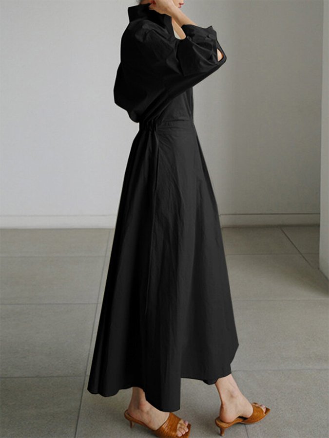 Robe longue élégante beige Clémence de Danoir Paris portée, en tissu fluide avec décolleté subtil et manches longues.
