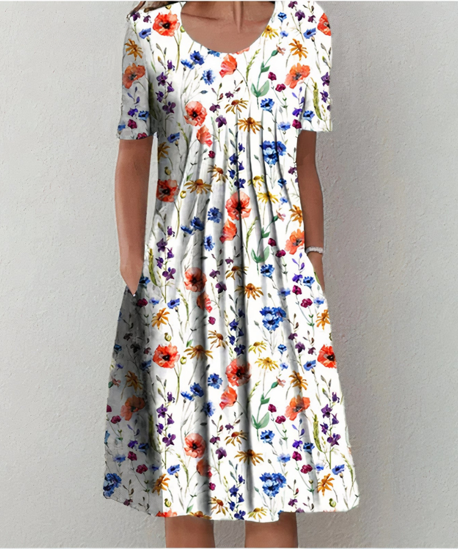Robe florale élégante Danoir Paris avec motif blanc et rouge, portée par la modèle, style chic et féminin.