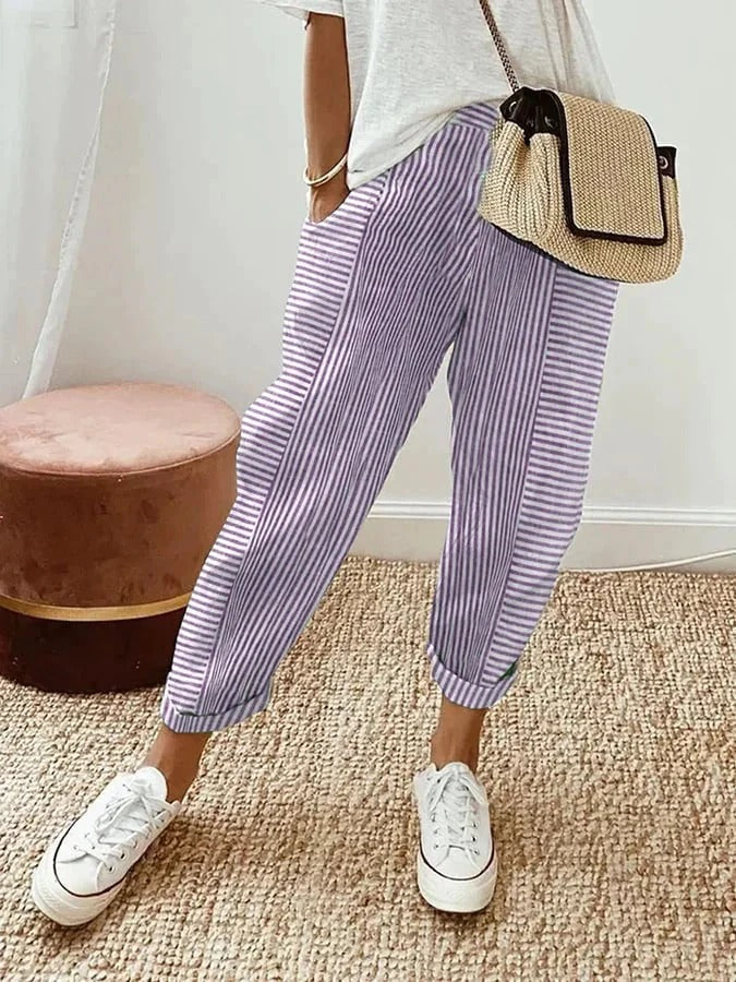 Pantalon rayé Lore de Danoir Paris, coupe ajustée, tissu bleu et blanc, porté avec une ceinture, vue de face.