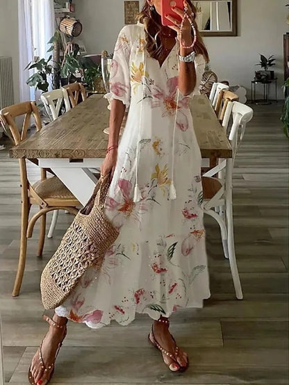Robe bohémienne légère Dianna de Danoir Paris en tissu bleu avec motifs floraux, portée avec manches courtes et style décontracté.