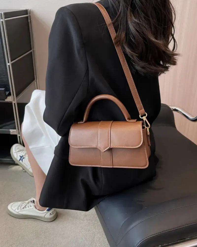 Sac à main The Paris de Danoir Paris en cuir marron, avec poignées et fermeture élégante.