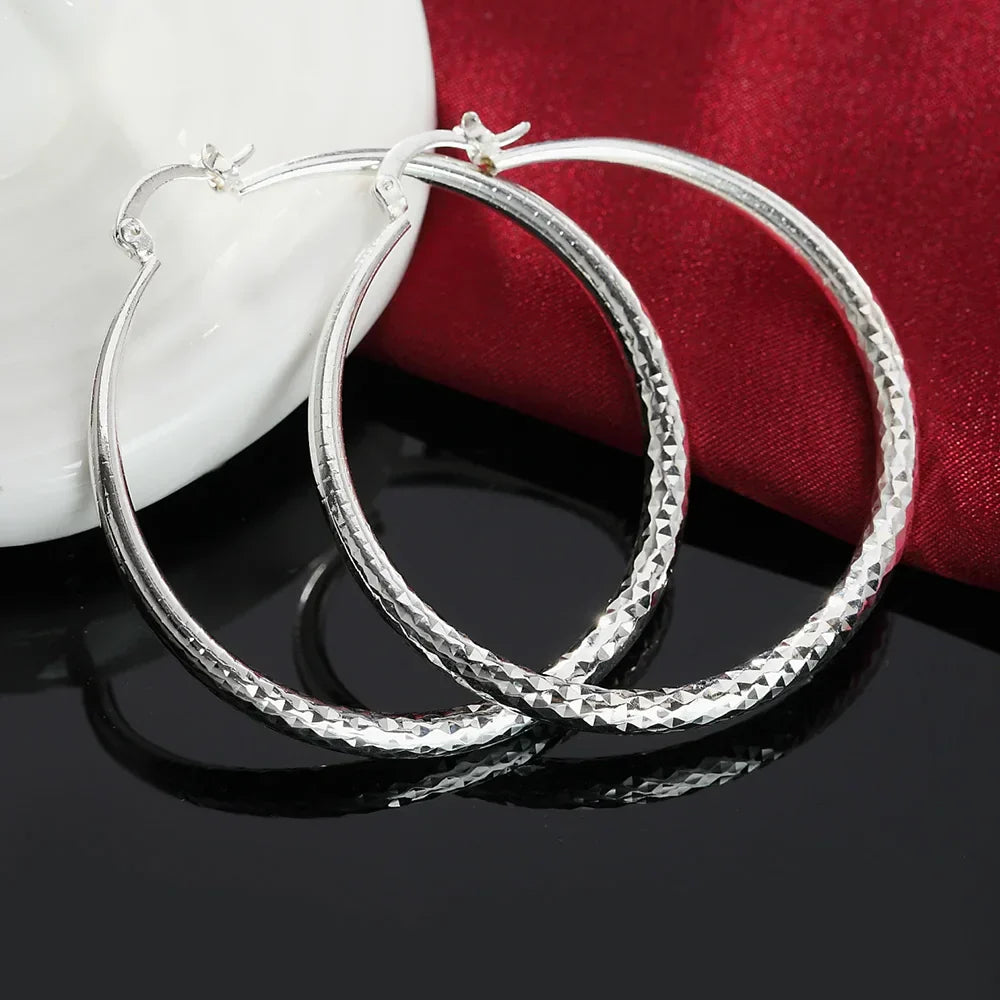 Boucles d'oreilles en argent sterling Danoir Paris avec design élégant et finition brillante, visibles en détail dans l'image.