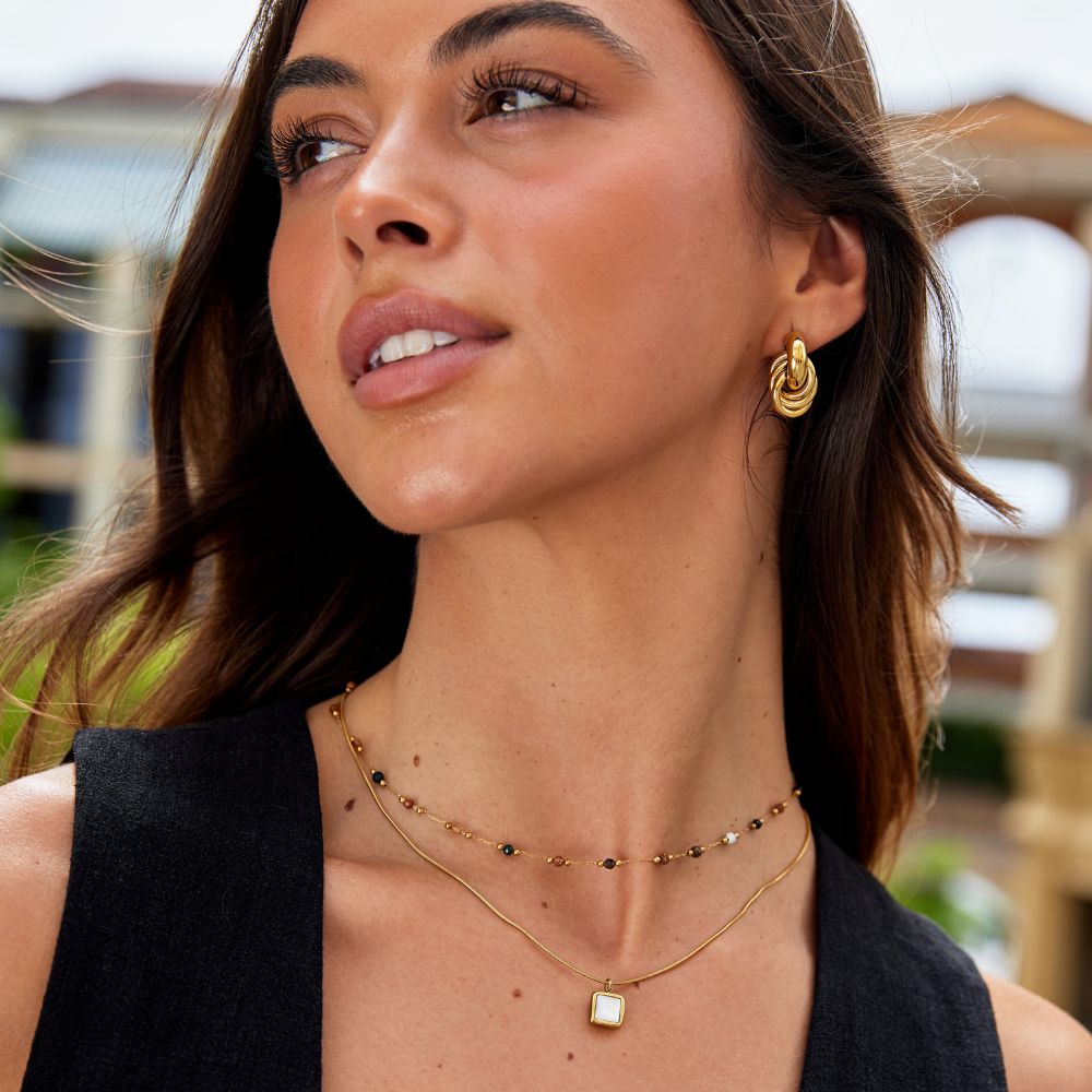 Collier minimaliste en pierre avec pendentif en lune en pierre de lune, signé Danoir Paris, sur fond clair.