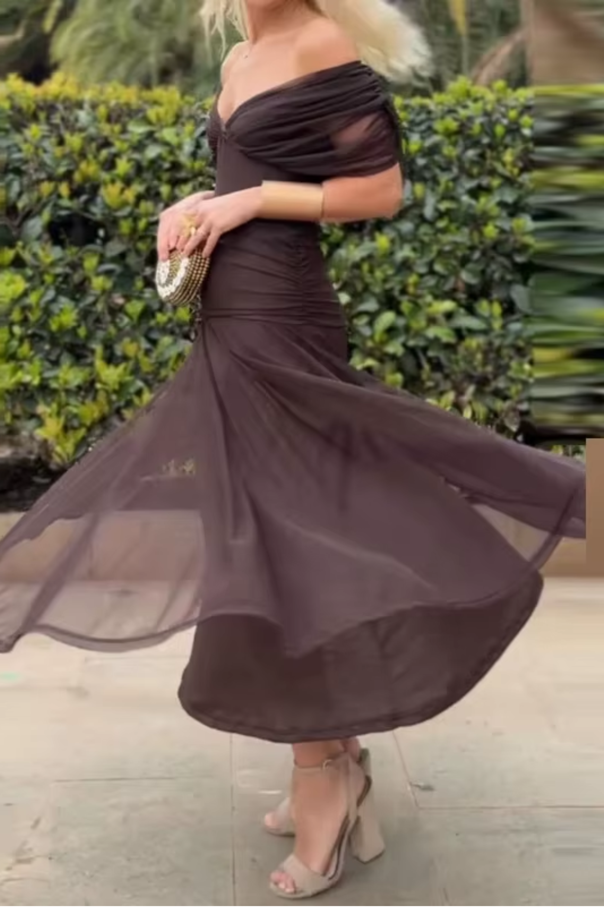 Robe maxi de fête verte à col V élégante de la marque Danoir Paris, portée avec un drapé fluide et des détails sophistiqués.