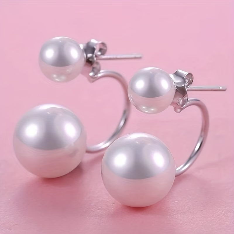 Boucles d'oreilles Danoir Paris avec double perle, statement, en métal précieux, élégantes et modernes, portées sur une femme.
