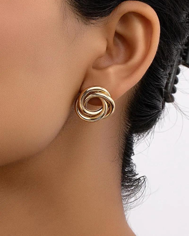 Boucles d'oreilles en forme de nœud Aurelia de Danoir Paris, en métal, visibles sur une image détaillée.