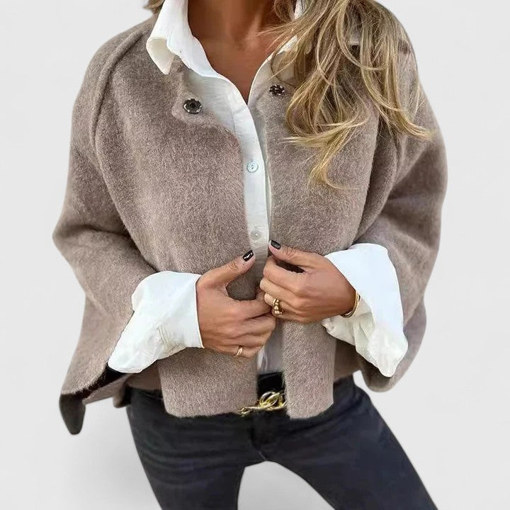 Veste élégante Bettinna de Danoir Paris en kaki, coupe ajustée, portée en extérieur, détail de finition sophistiquée.