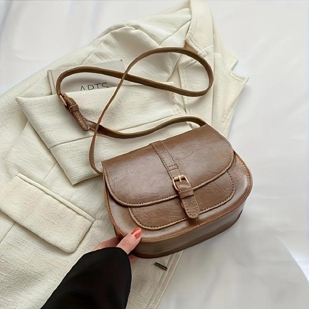 Sac à main Sienna de Danoir Paris en cuir marron foncé, design intemporel et élégant, avec poignées et détails raffinés.