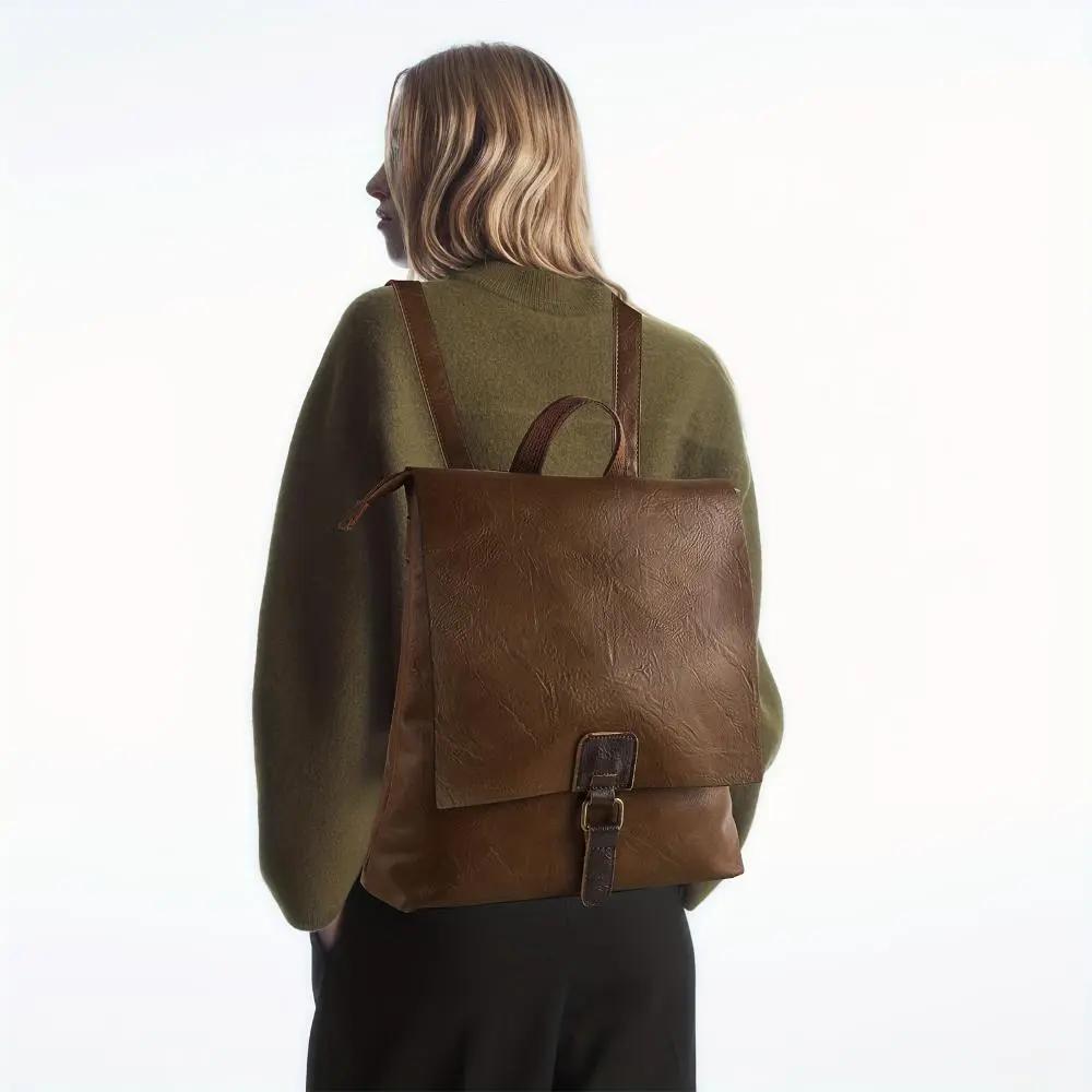 Sac à dos Danoir Paris Nina en cuir marron, style vintage, polyvalent et élégant, avec poignées et compartiments pratiques.