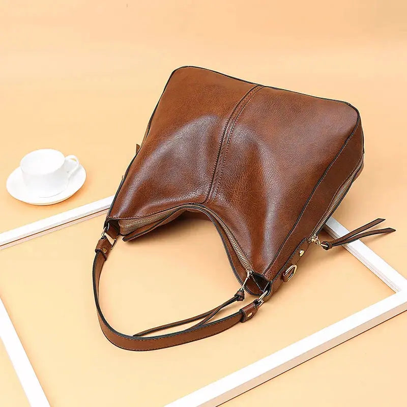 Sac élégant Romy en cuir marron de Danoir Paris, avec poignée et design sophistiqué, parfait pour une tenue chic.