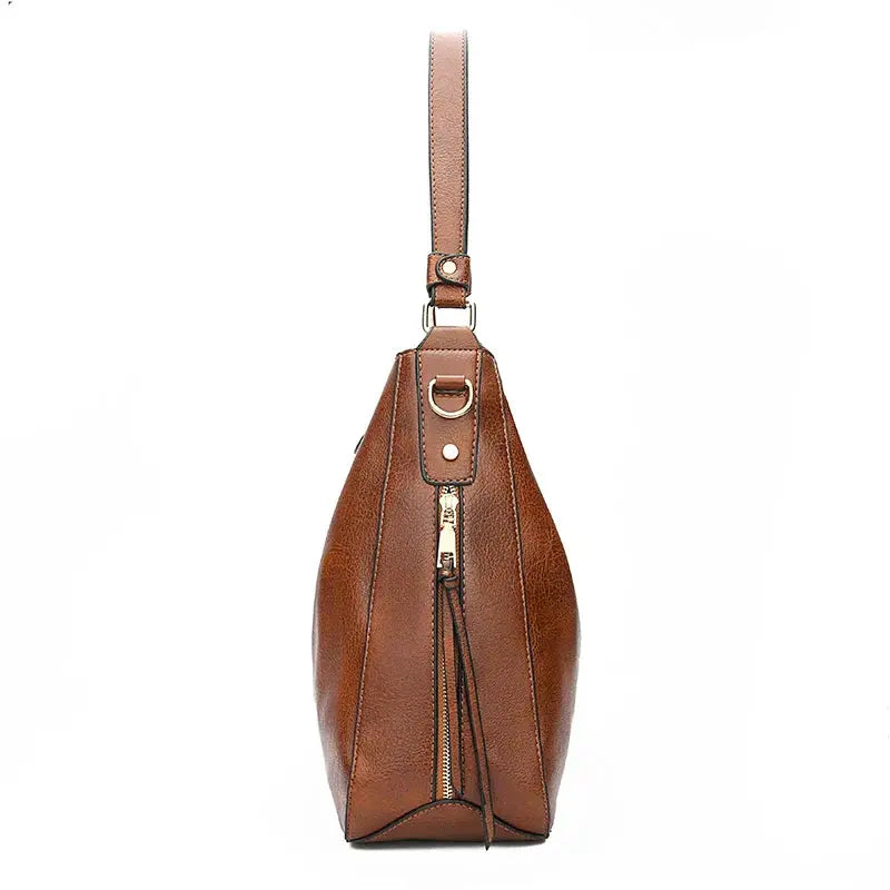 Sac élégant en cuir marron Romy de Danoir Paris, porté avec bandoulière et détails sophistiqués.