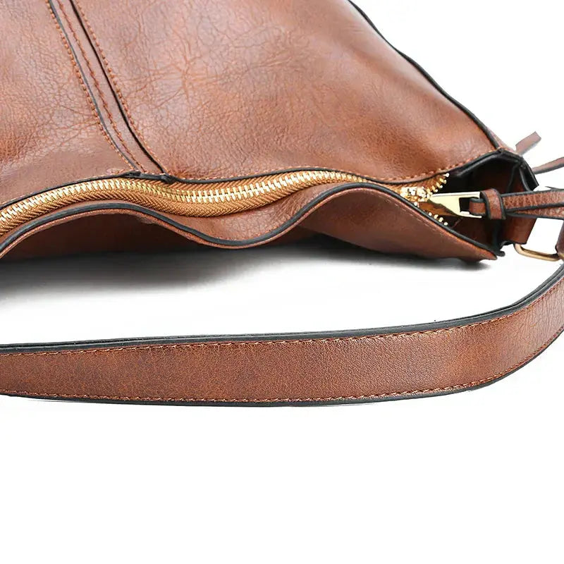 Sac élégant en cuir marron Romy de Danoir Paris, avec poignées et détails sophistiqués pour un style chic et intemporel.
