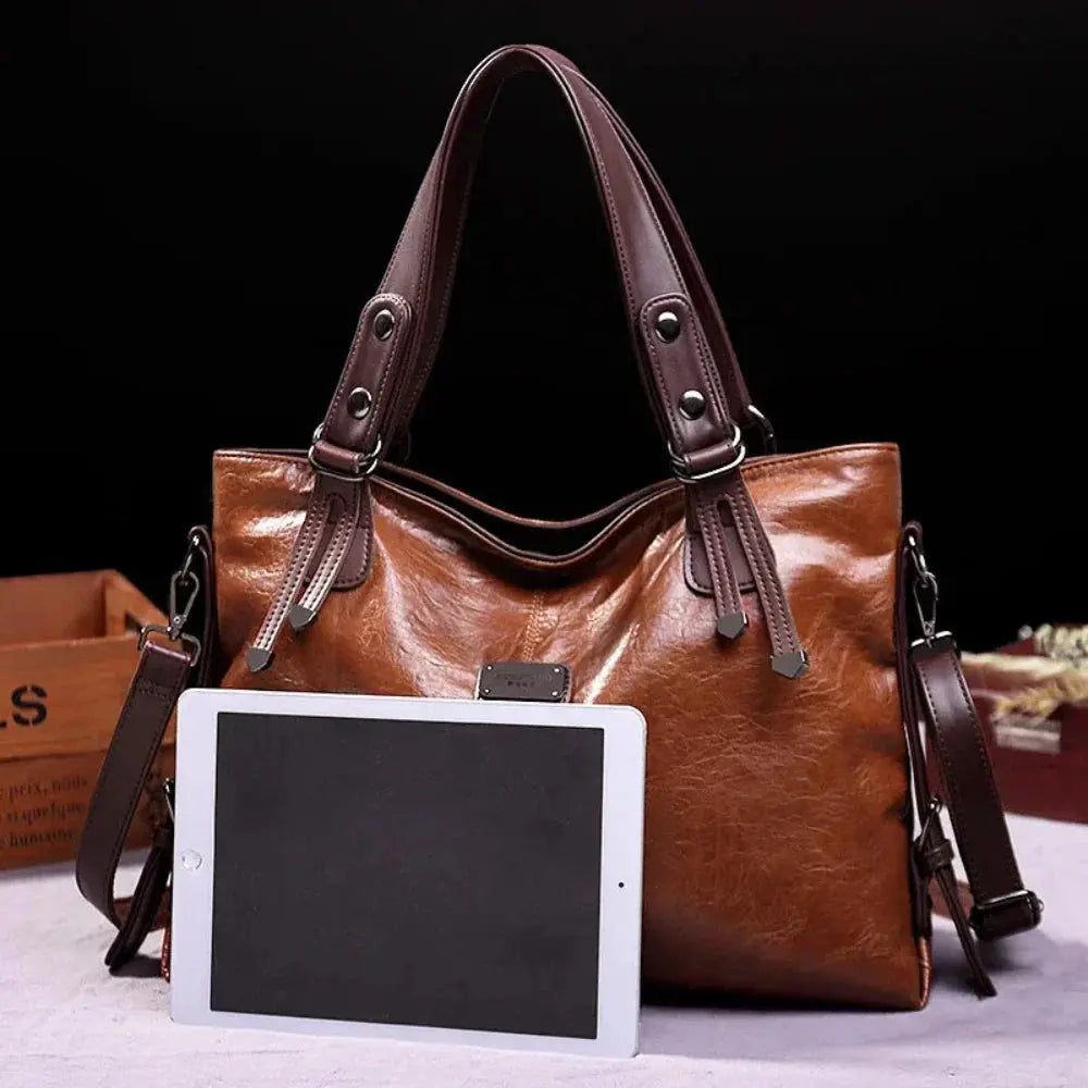 Sac de voyage Sienna de Danoir Paris, en cuir marron, avec poignet et bandoulière, style intemporel et élégant.