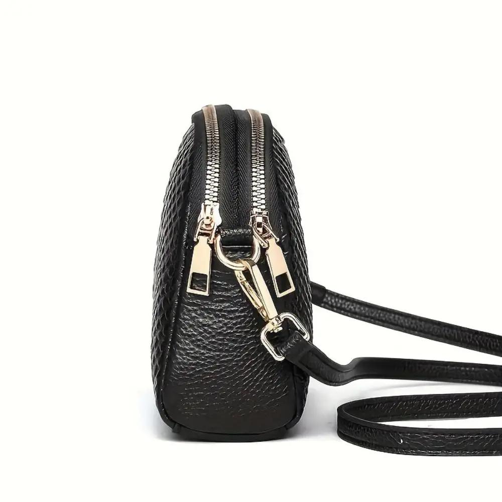 Mini sac à bandoulière Cora en simili cuir noir avec motif crocodile, par Danoir Paris.