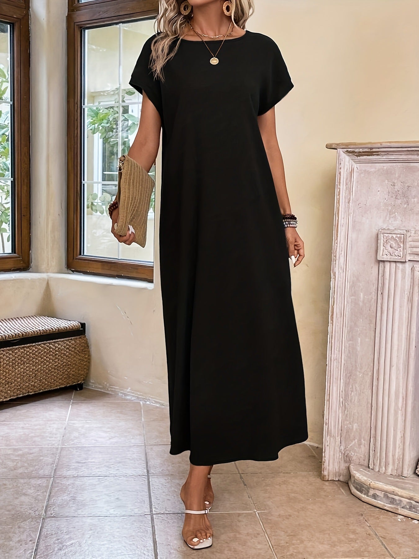 Robe longue élégante et minimaliste Margaux™ de Danoir Paris, en tissu noir, portée avec simplicité et sophistication.