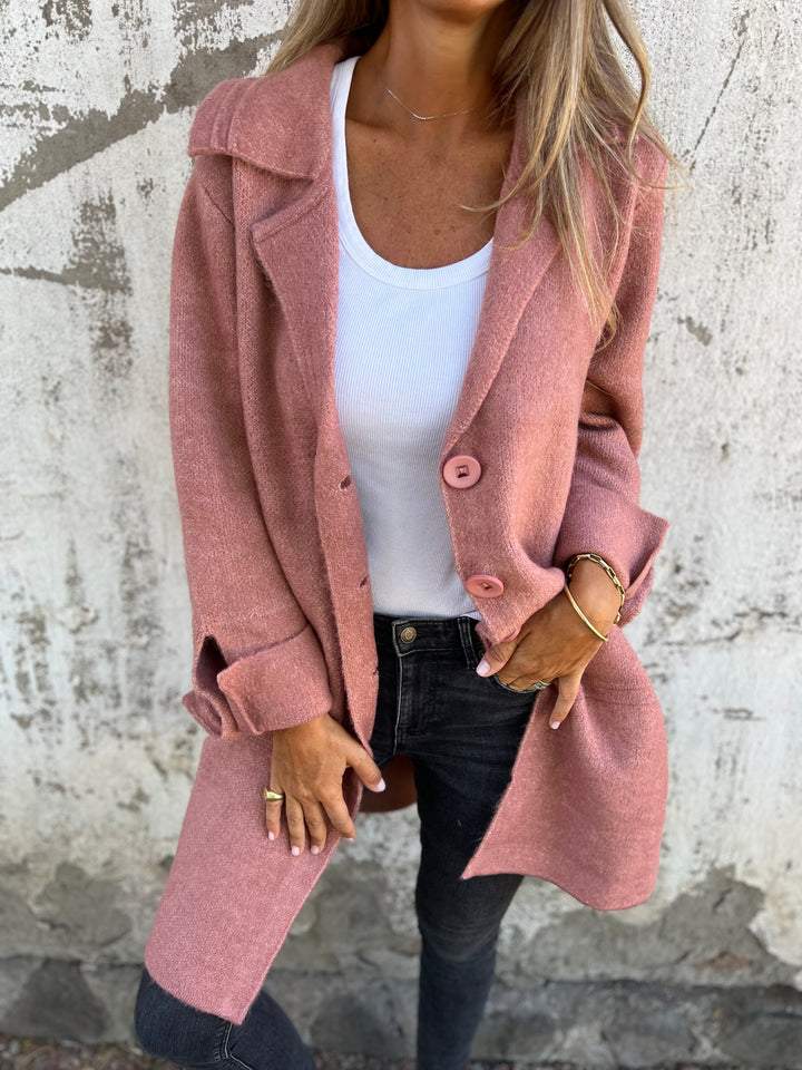 Manteau chic minimaliste Audrey de Danoir Paris en tissu rose, avec coupe élégante et détails sophistiqués.