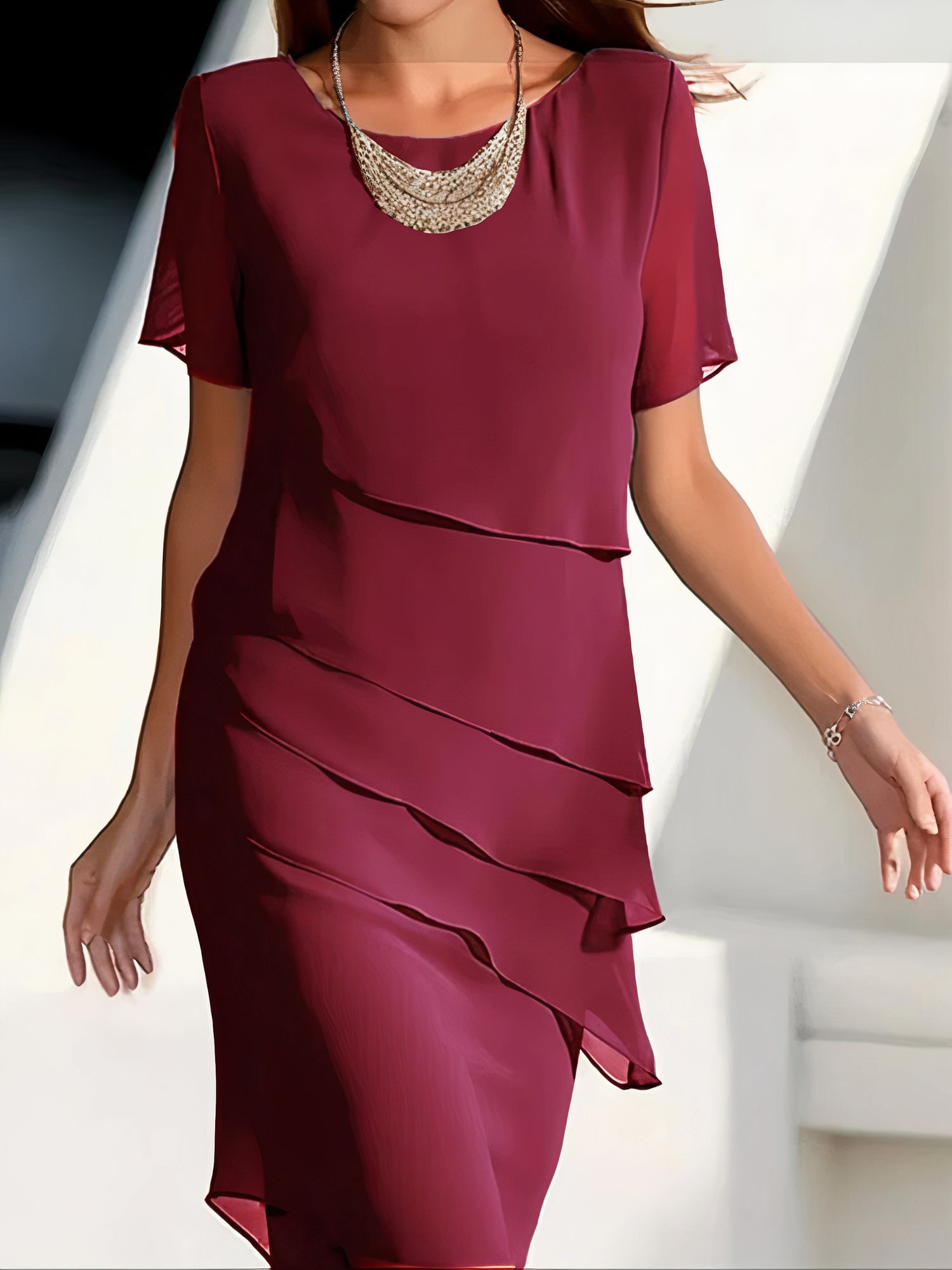 Robe plissée rouge Louise de Danoir Paris, élégante et sophistiquée, portée sur un fond neutre.