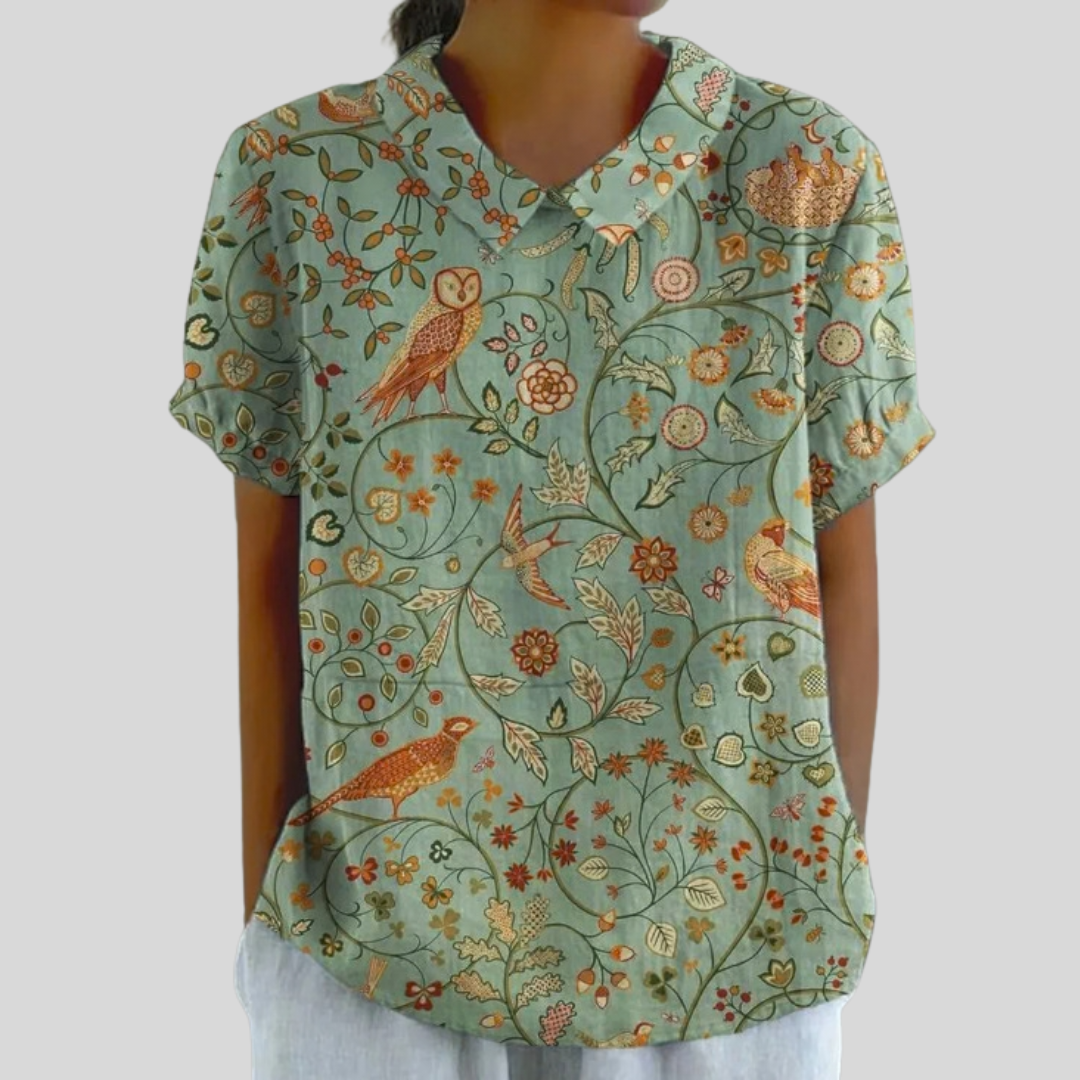 Blouse Danoir Paris Apolline Forêt Enchantée en tissu léger, avec motifs floraux et détails élégants sur fond vert.
