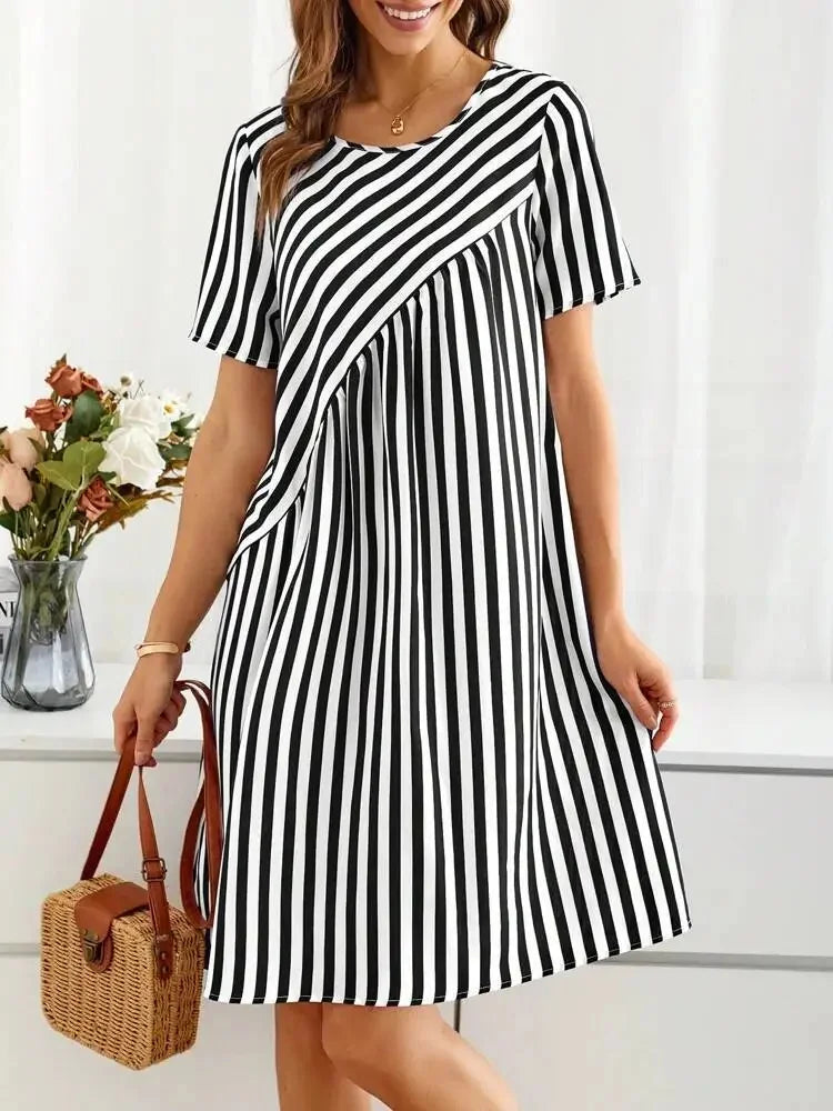 Robe d'été rayée Clara de Danoir Paris, en tissu léger rouge et blanc, portée avec manches courtes et style décontracté.