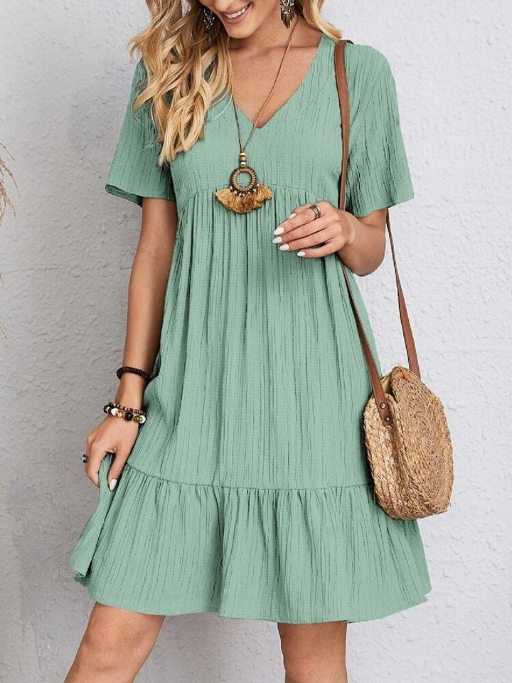 Robe élégante de couverture du ventre Aisha par Danoir Paris, tissu vert, style confortable et sophistiqué.