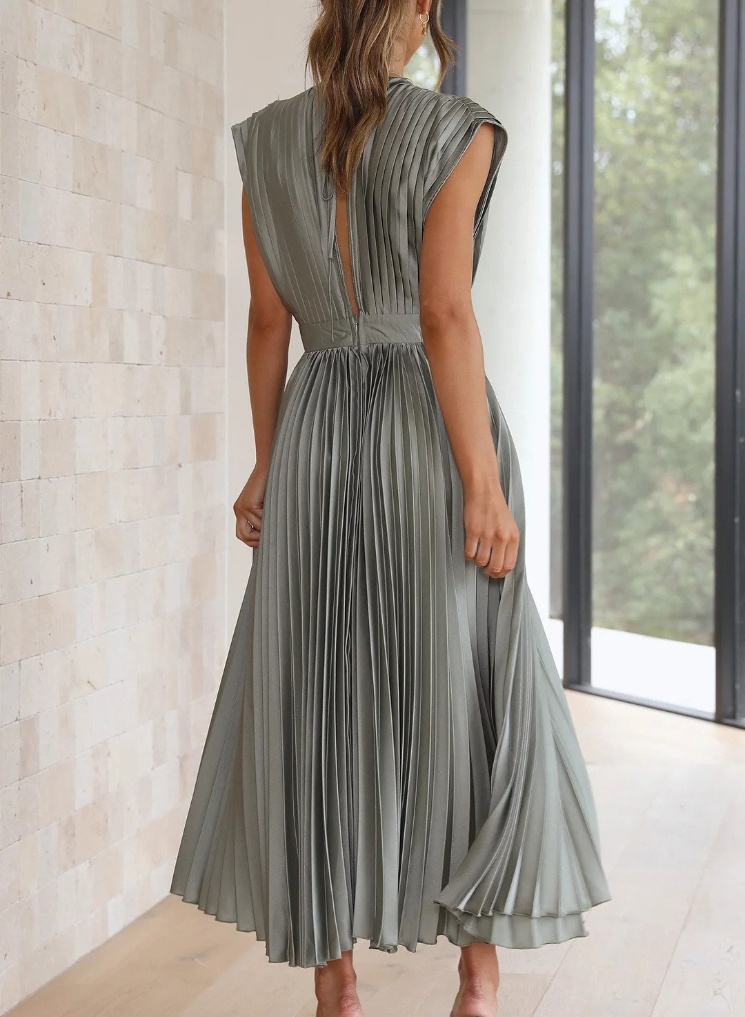 Robe longue élégante Chiara de Danoir Paris, en vert, vue en détail sur un fond neutre.