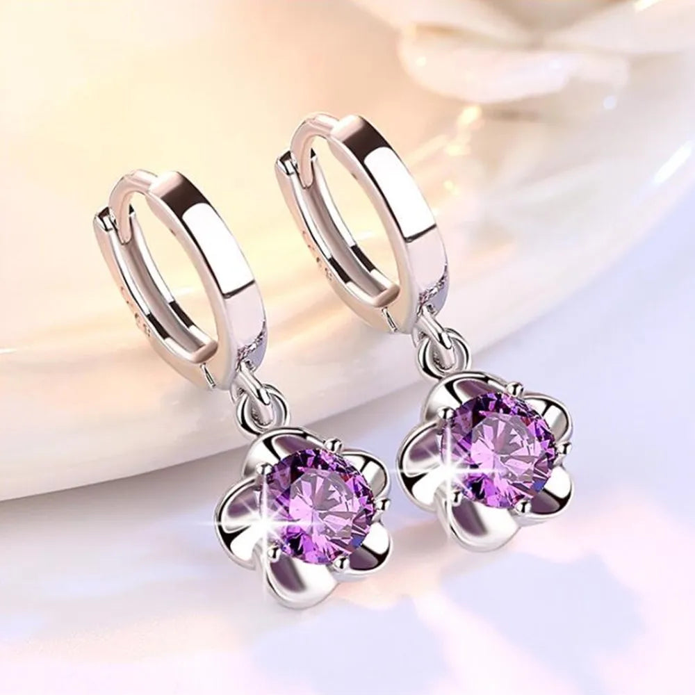 Boucles d'oreilles en argent sterling avec zircons violets et blancs, de la marque Danoir Paris, visible en gros plan.