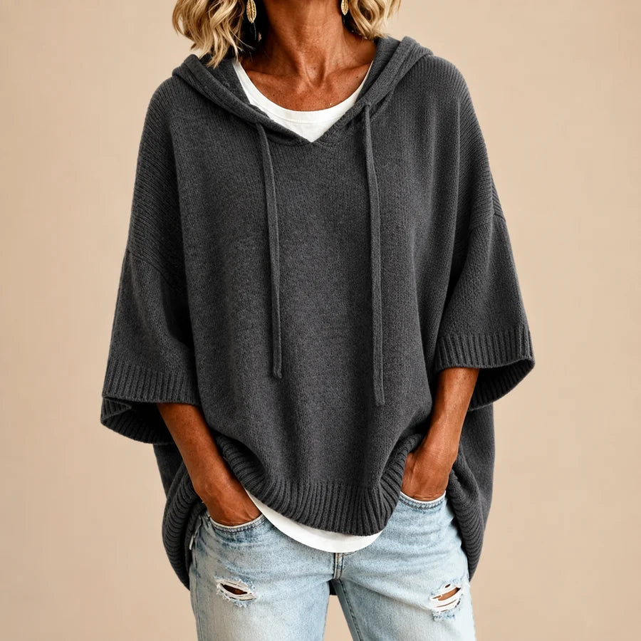 Poncho en tricot bleu marine avec capuche de la marque Danoir Paris, vue en gris sur l'image.