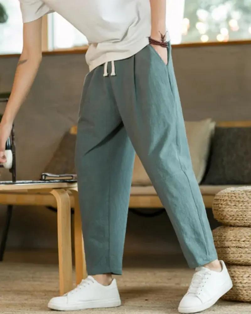 Pantalon en coton beige Old Money Cancun, coupe décontractée, porté sur un fond neutre, détail de la texture du tissu.