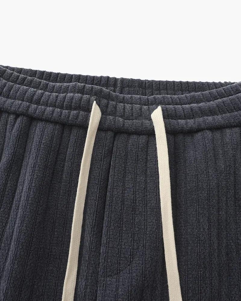 Pantalon en velours roman noir Old Money, coupe ajustée, tissu doux et élégant, vu de face sur fond blanc.