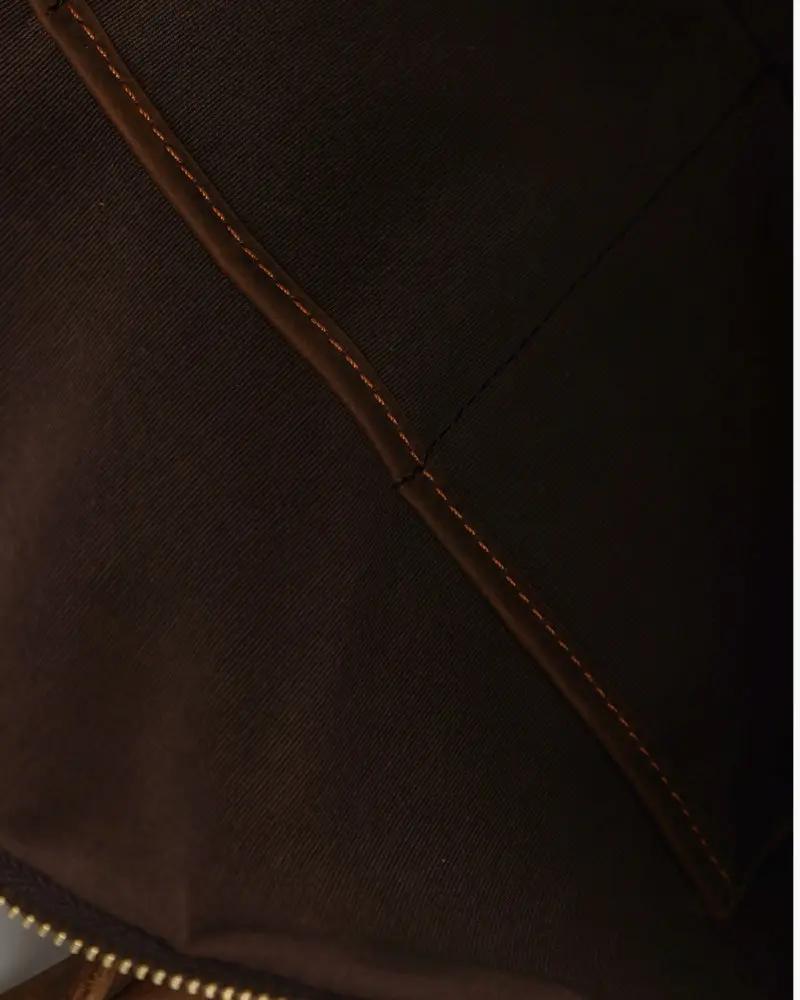 Sac de voyage en cuir marron Montague d'Old Money, avec poignées en cuir et fermeture zippée élégante.