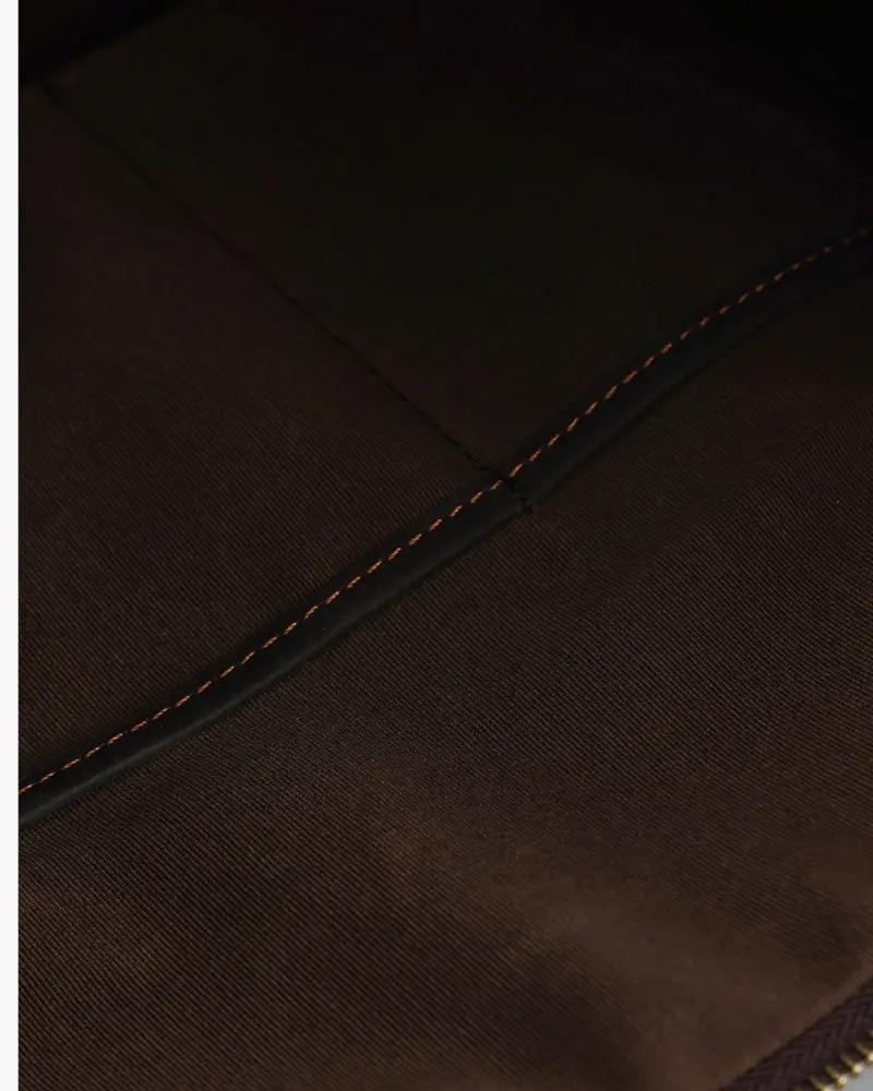 Sac de voyage en cuir marron Montague de la marque Old Money, avec poignées solides et fermeture à glissière.