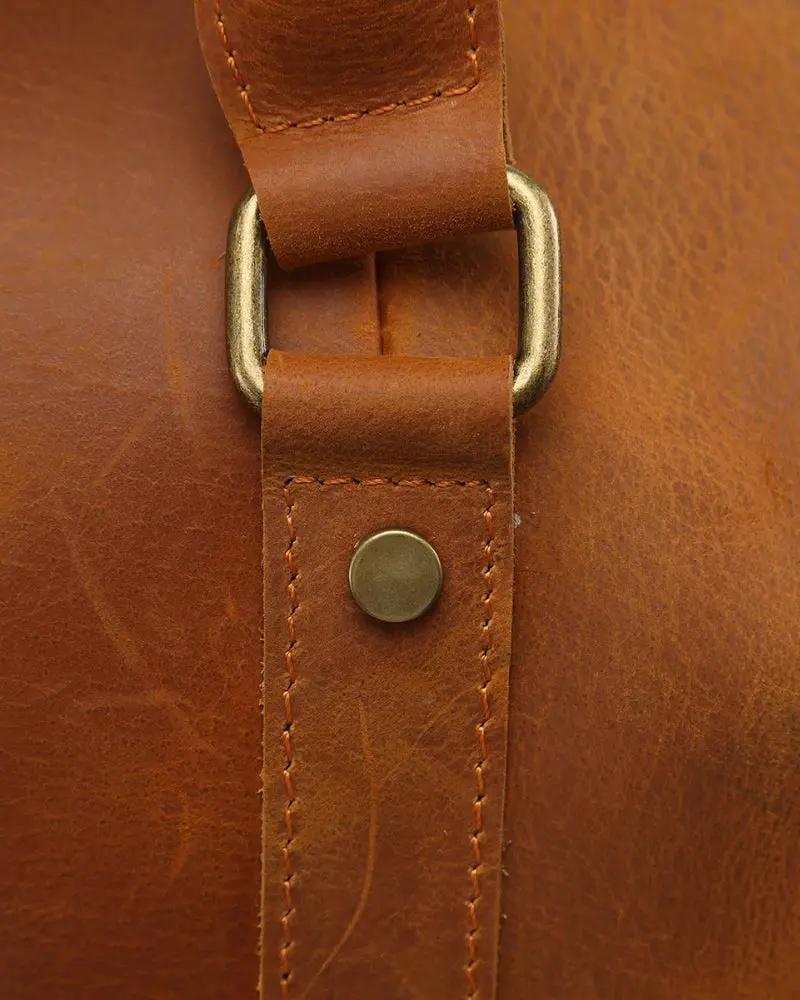 Sac de voyage en cuir marron Montague de la marque Old Money, avec poignées et fermeture robuste.