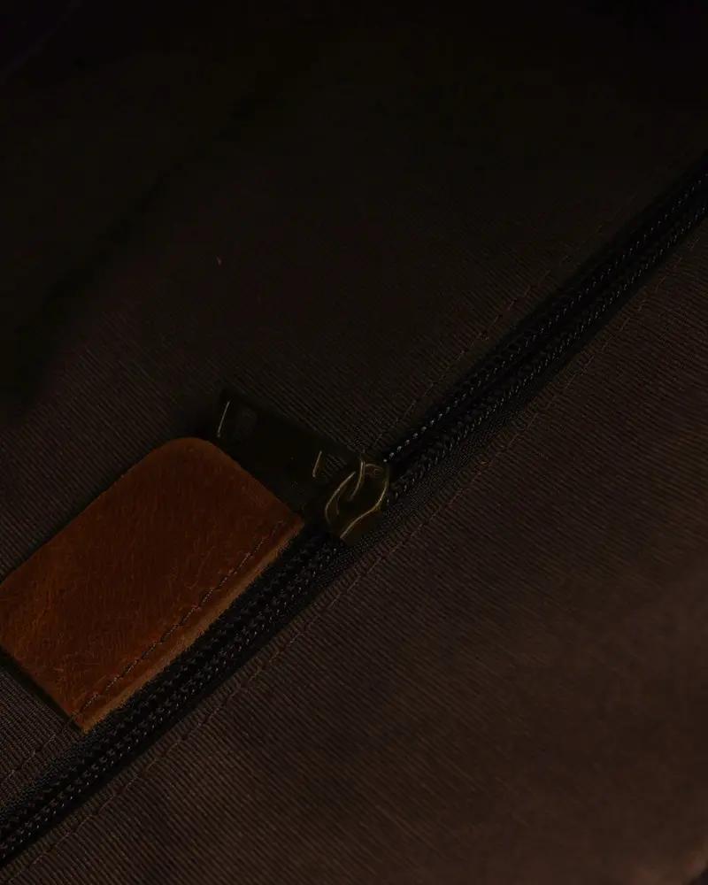 Sac de voyage en cuir marron Montague de la marque Old Money, avec poignées et fermeture à glissière visible sur l'image.