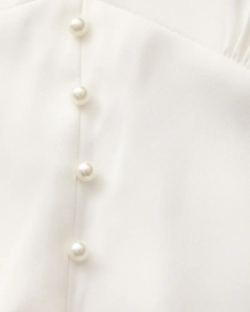 Robe midi à volants avec boutons en perles de la marque Old Money Women, tissu léger et élégant, vue de face.
