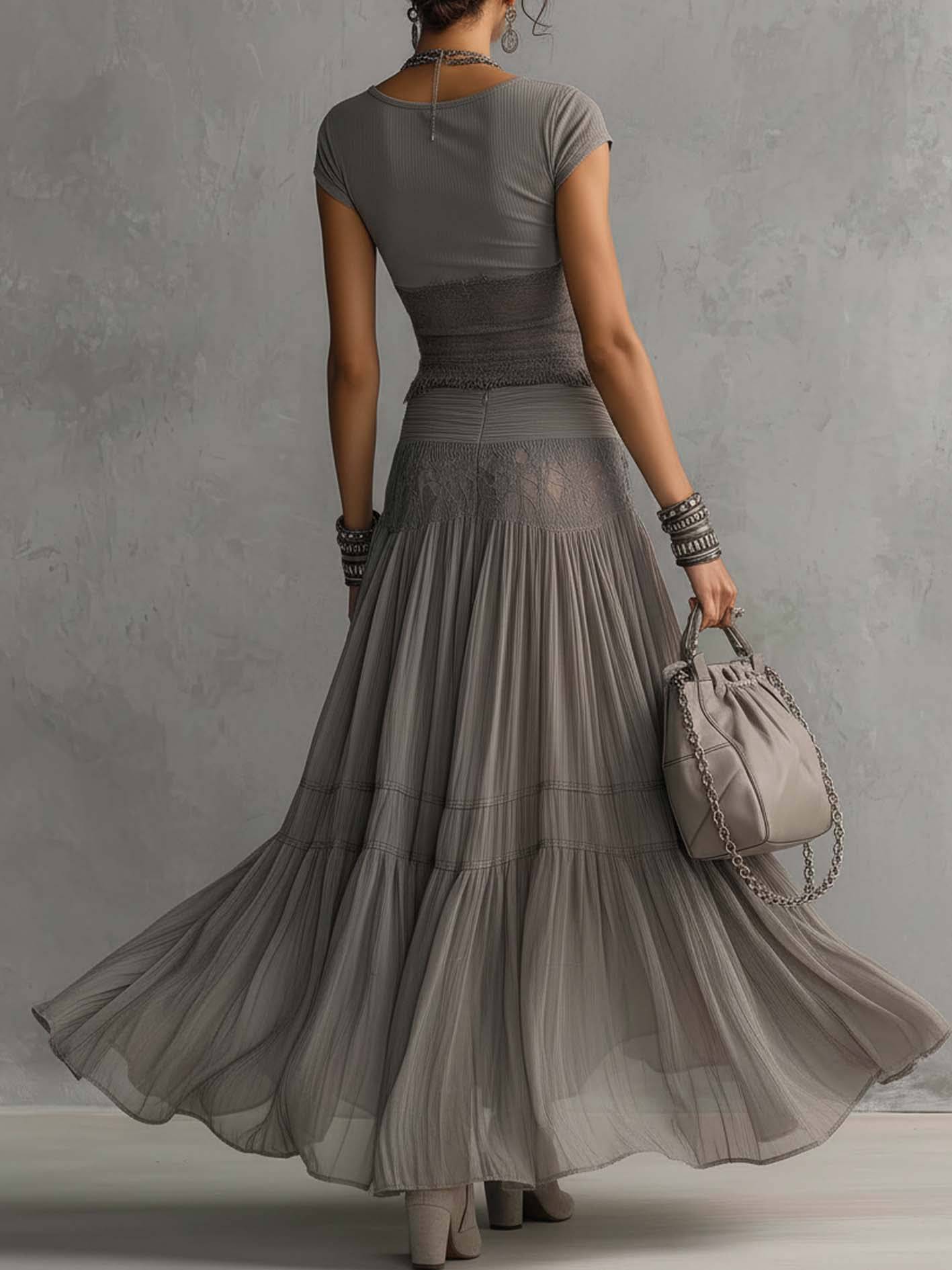 Ensemble coordonné gris avec top en dentelle transparente et jupe longue plissée, de la marque Danoir Paris.