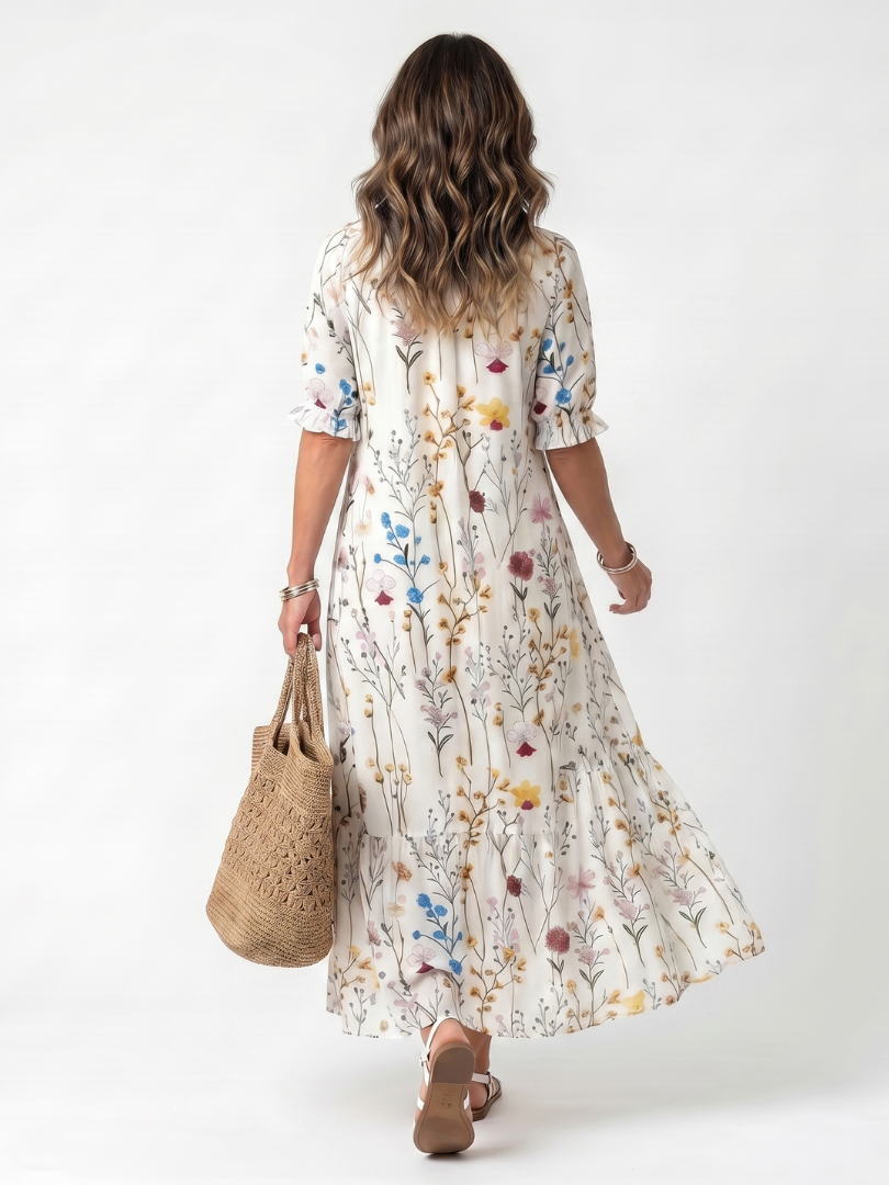 Robe midi à motif botanique Danoir Paris avec franges, manches longues et coupe fluide, portée en extérieur.