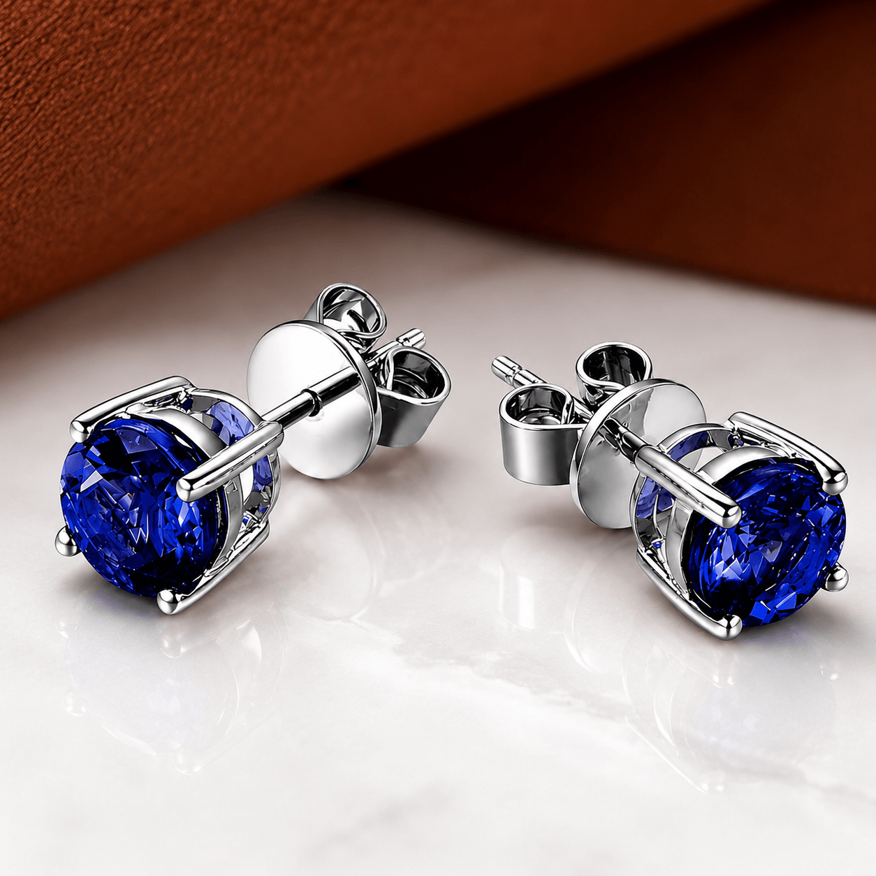Boucles d'oreilles en sapphires princesse minimalistes de Danoir Paris, visibles avec pierres précieuses et monture élégante.