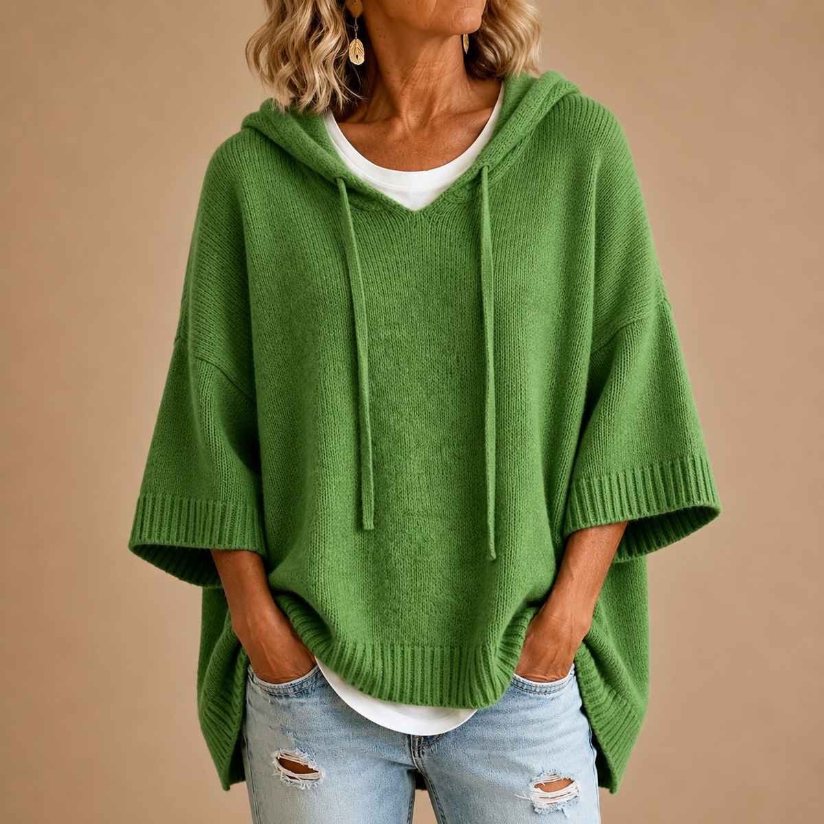 Poncho en maille avec capuche MIRELLA™ de Danoir Paris, porté en extérieur, en tissu doux et chaud, couleur neutre.