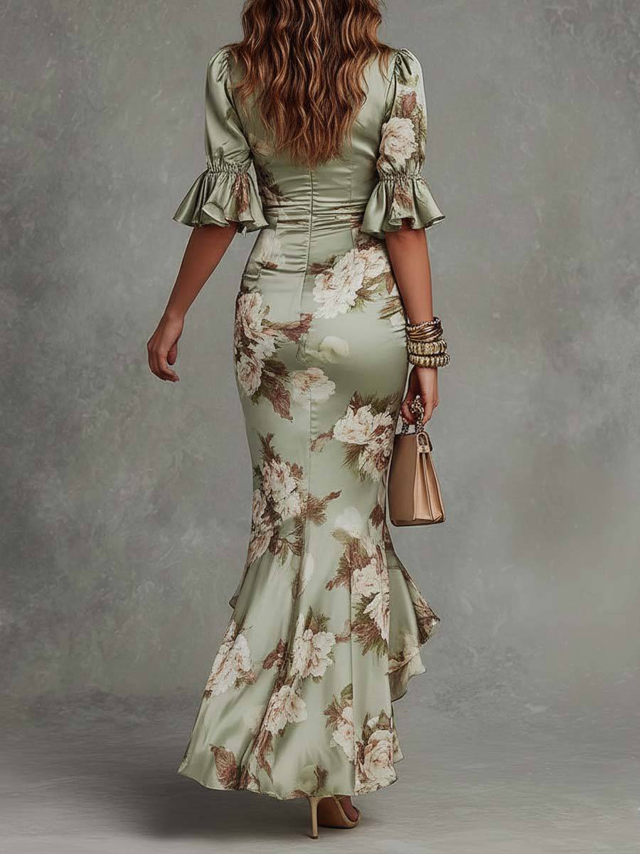Robe longue satin verte à fleurs, manches ballons à volants, col en V et coupe asymétrique, par Danoir Paris.