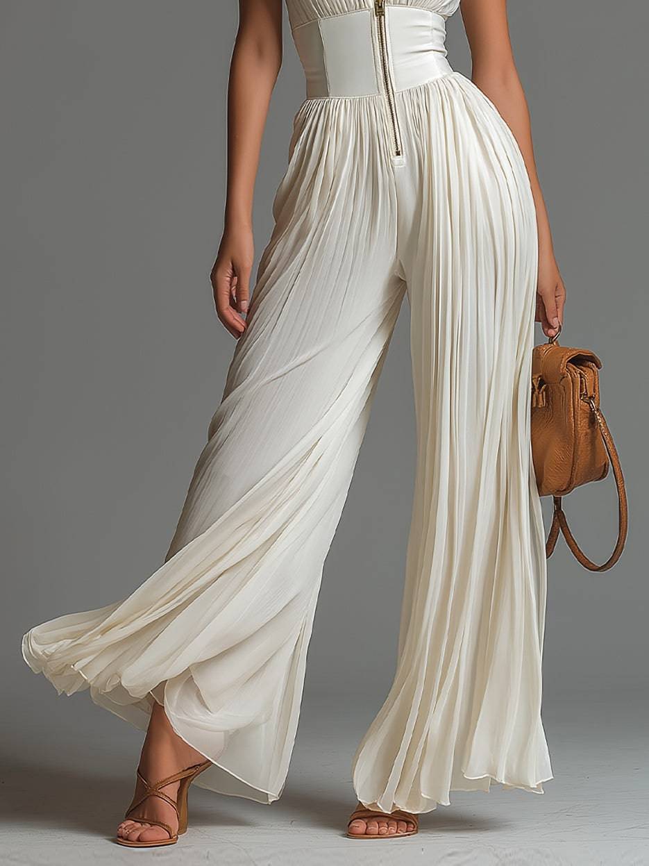 Combinaison blanche sans manches à col en V, fermeture éclair, plis et jambes larges en chiffon par Danoir Paris.