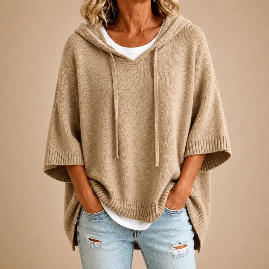 Poncho en tricot bleu marine avec capuche, conçu par Danoir Paris, visible en image avec texture douce et style décontracté.
