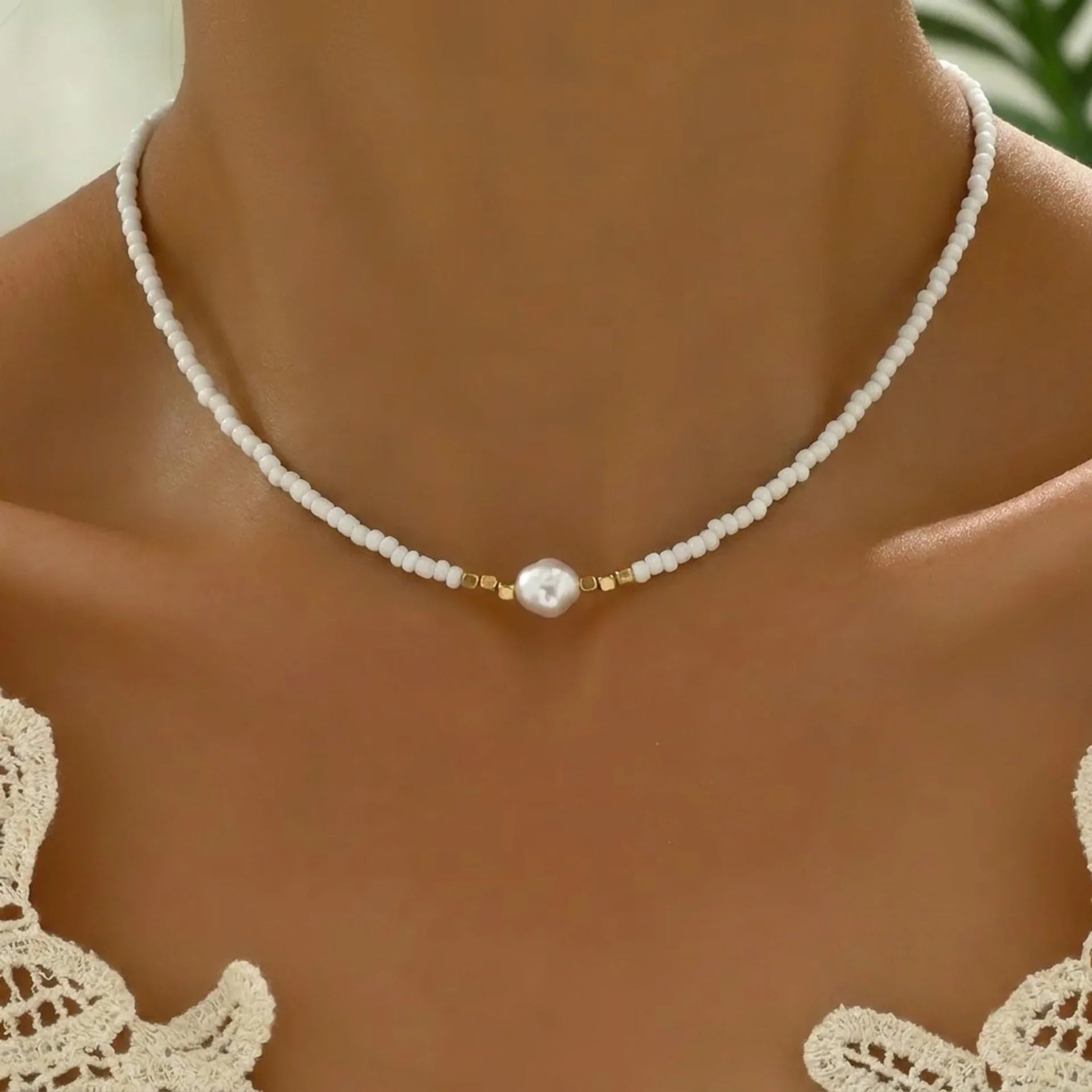 Collier minimaliste turquoise et perles de la marque Danoir Paris, élégant et discret, porté sur un fond neutre.