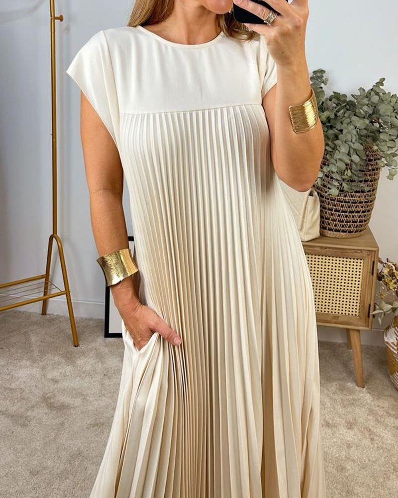 Robe longue beige Sylvie de Danoir Paris, élégante et fluide, portée avec des détails sophistiqués, vue de face.