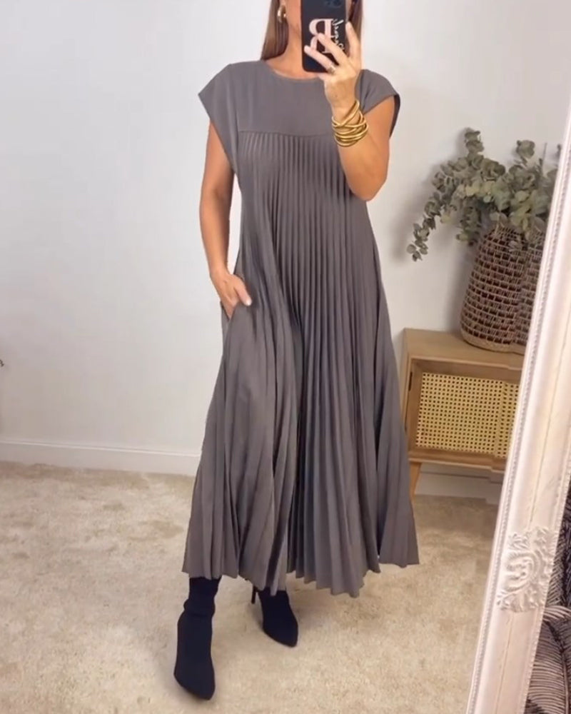 Robe longue élégante Sylvie en beige de Danoir Paris, tissu fluide et coupe sophistiquée, portée avec accessoires.